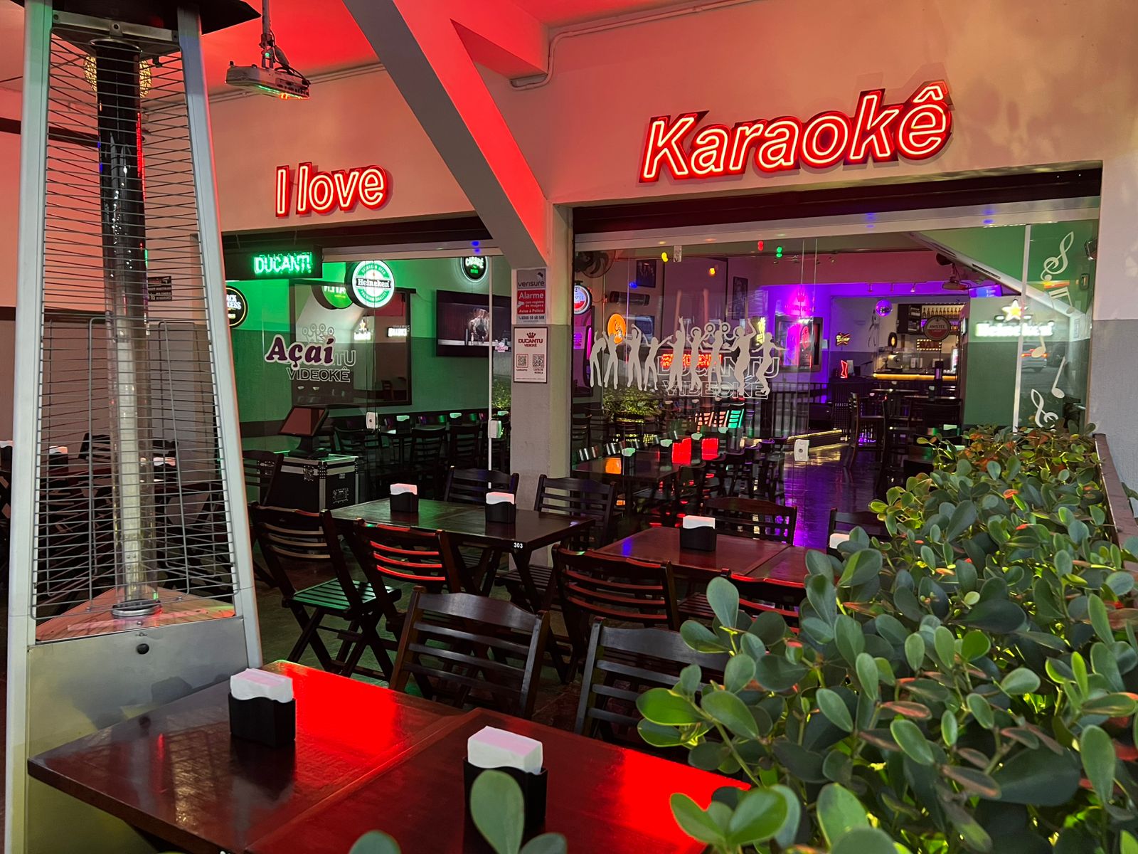 Área externa com letreiro I love Karaokê em neon